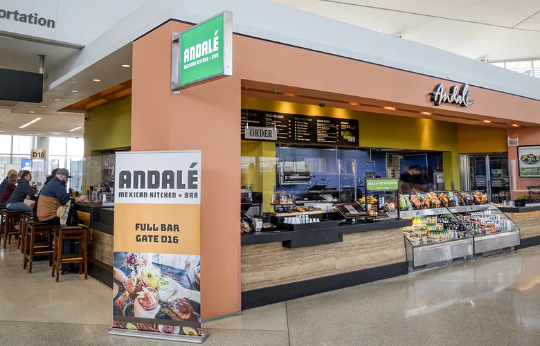 View of Andale in Terminal 2, showing people seated at bar area, ordering counter, and grab -and-go items